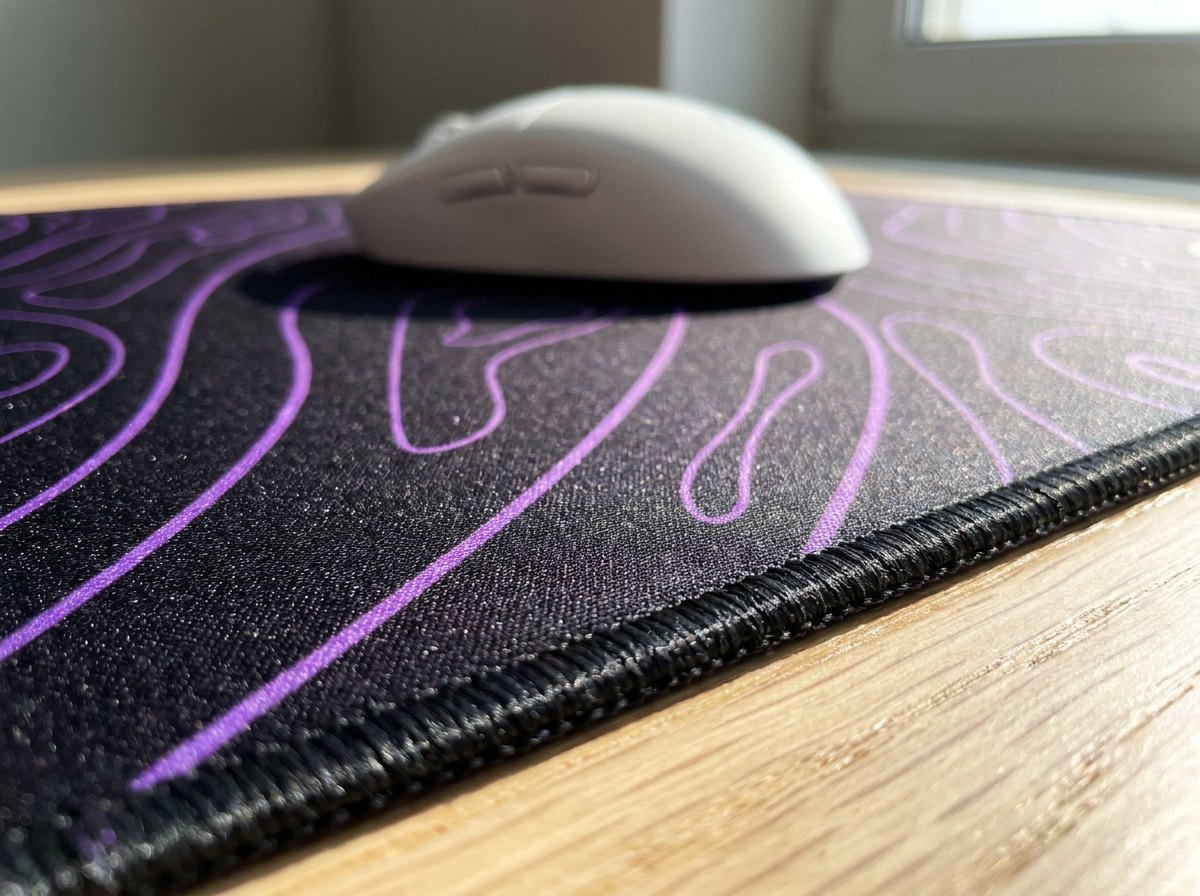 Close-up of the stitched edge and woven surface of a Purple Black Damascus mat